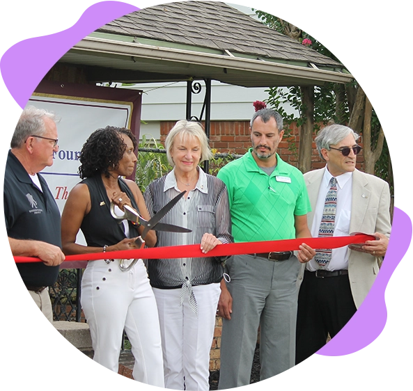 Ribbon cutting ceremony with four people.