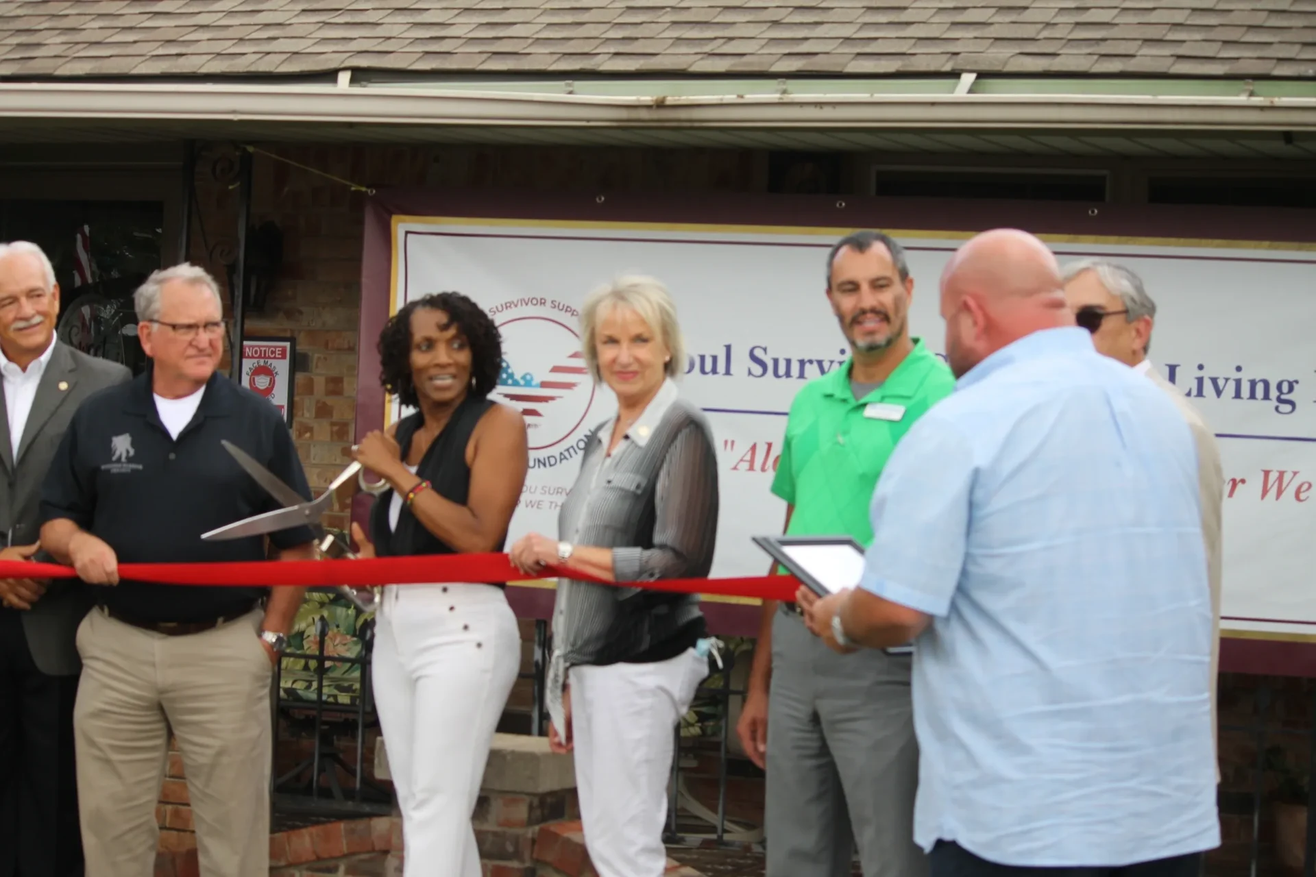 Ribbon cutting ceremony for a survivor support foundation.