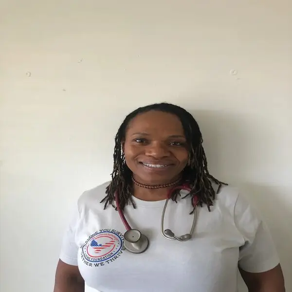 Smiling woman wearing a stethoscope and a white shirt.