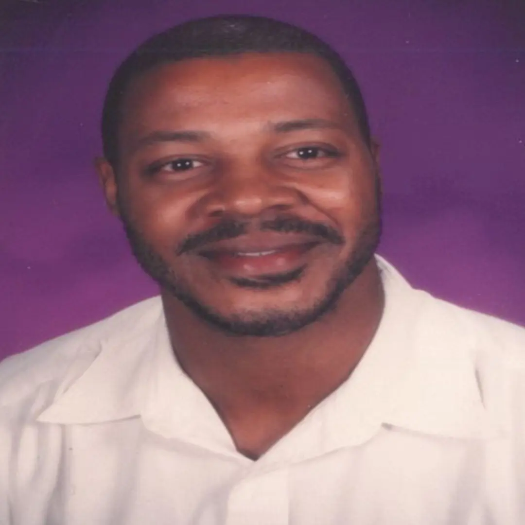 A smiling man in a white shirt.